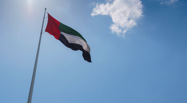 United Arab Emirates flag flying against sky. UAE celebrates it's national day on 2nd December every year.