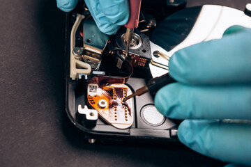 Computer service engineer technician workplace repairing fixing disassembled HDD hard drive data disc SSD, using multimeter ammeter. Recovery, maintenance work, access file. Profession repairman

