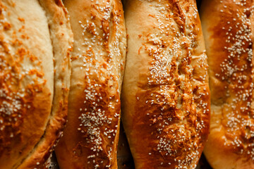 Close up shot homemade food baking concept. Fresh hot soft fluffy ginger golden brown sesame seeds buns pie bread dessert pastry in loaf pan. Bakery products, image with copy space.