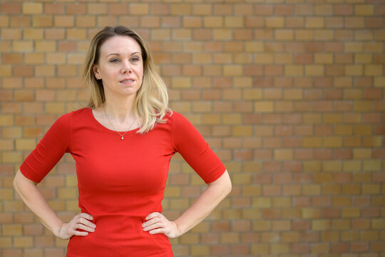Blonde woman in front of a brick wall
