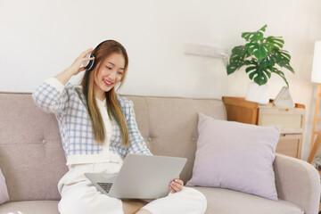 Leisure time concept, Women sitting on comfortable couch and wearing headphone to watching movie