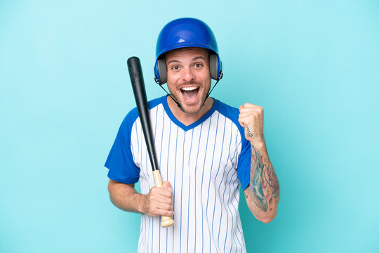 Baseball player with helmet and bat isolated on blue background celebrating a victory in winner position