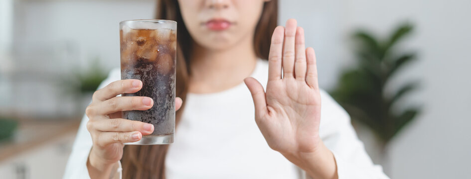 Close-up Hands Of A Person Holding A Soda Sugar Glass And Showing A Hand Sign Stop To Diet Sugar For Health.