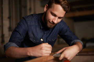 Carpentry, measurement and happy man with pencil, wood and designer furniture manufacturing workshop. Creativity, small business and smile, expert carpenter working on sustainable project design.