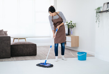 Portrait Of Young Woman Mopping Floor At Home