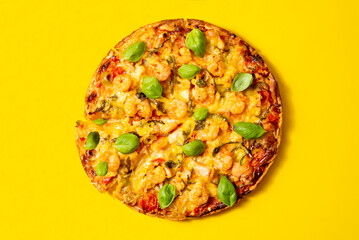 Pizza Marinara with seafood, shrimp and salmon top view on a yellow background.