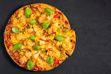 Pizza Marinara with seafood, shrimp and salmon top view on a black background.
