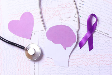 Purple ribbon, stethoscope and purple heart shape on encephalogram paper, integrated electrical...