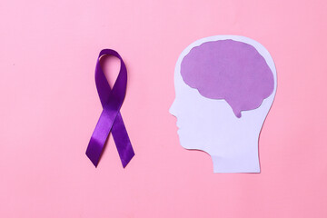 Purple ribbon with brain paper cutout isolated on pink background. 