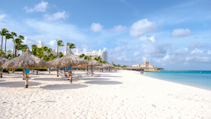 Palm Beach Aruba Caribbean, white long sandy beach with palm trees at Aruba Antilles. - obrazy, fototapety, plakaty