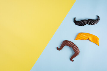 Curly mustaches on colorful background. Fake mustache. Top view