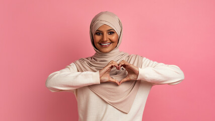 Love Concept. Smiling Muslim Woman In Hijab Showing Heart Gesture At Camera