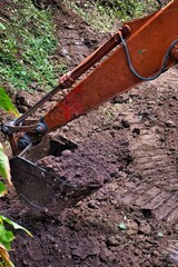Fototapeta premium Shovel excavator moving a pile of rich brown soil
