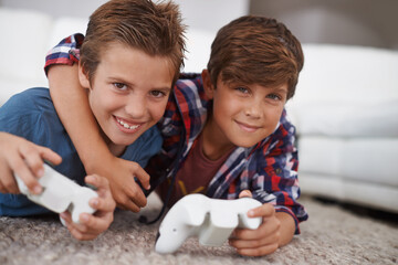 Boys playing video game, friends in portrait and gaming with technology, esports and entertainment in living room. Gamer kids play games on console at home, youth and male children have fun together © Jeff Bergen/peopleimages.com