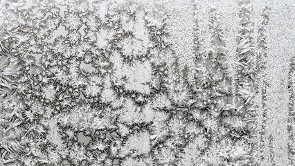 panoramic natural background - monochrome frozen pattern on surface on home window glass close up on cold winter day