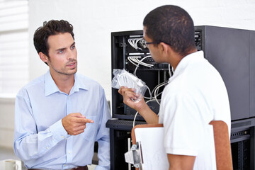 Server room, it support and wires with an engineer talking to a business man about hardware or cable replacement. Network, database and spare parts with a technician explaining information technology