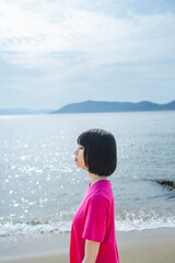 Fototapeta na wymiar 晴天の海を散策する女性