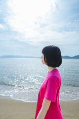 晴天の海を散策する女性