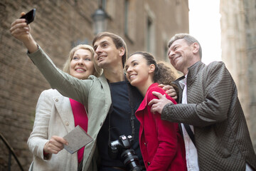 tourists taking selfie on old street of European city