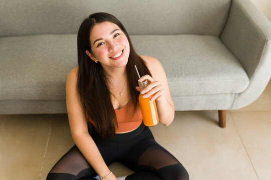 Attractive vegetarian woman drinking a carrot vegan juice