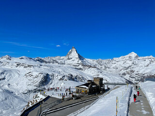 Scenic view of snow covered Swiss Alps with famous Matterhorn in the background seen from Gornergrat viewpoint on a sunny spring day. Photo taken March 23rd, Gornergrat, Zermatt, Canton Valais, 2021.