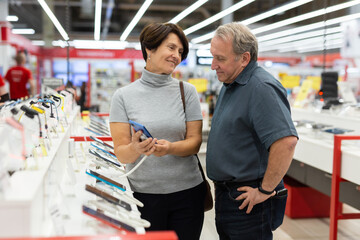 Elderly man and elderly woman choose mobile phone