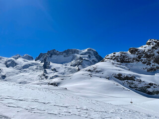 Obraz premium Scenic view of snow covered Swiss Alps seen from Gornergrat viewpoint on a sunny spring day. Photo taken March 23rd, Gornergrat, Zermatt, Canton Valais, 2021.