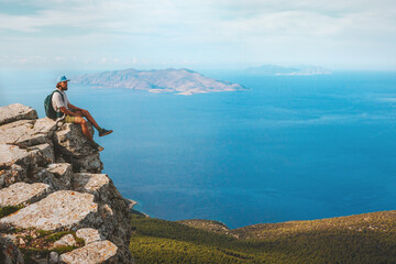Man exploring Rhodes island traveler sitting on cliff edge mountain hiking travel active vacations...