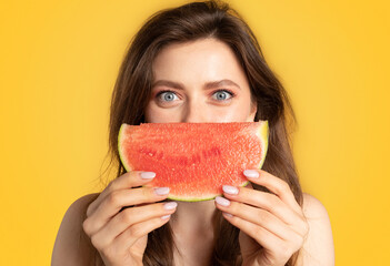 Summertime. Portrait of joyful lady having fun and posing with juicy watermelon near face, standing...