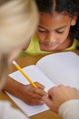 Closeup of teacher helping student, education and writing in notebook, teaching and learning for...