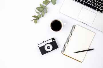 White background with retro camera, laptop, notebook and coffee, top view.