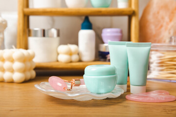 Care cosmetics on the shelf in the bathroom. Cosmetic tube. Cleanser, face and body cream, face roller and gua sha, tonic. Shelf with cosmetics in the interior of the bathroom.Beauty concept.