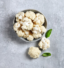 fresh cauliflower in a gray plate on a light gray background top view