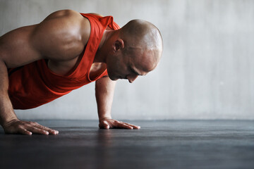 Workout, endurance focus and man doing push up for strength exercise, gym commitment and muscle...