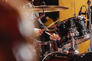 Fototapeta na wymiar Percussionist performing on rock drum set with drumsticks.