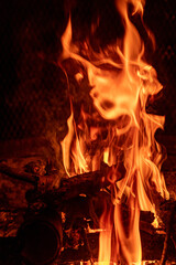 Close up shots of flames and natural wood in an outdoor fire pit at Night