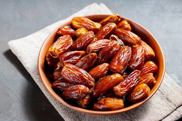 Delicious dried dates on a plate. Pitted dates on a dark background. Dried fruits for a healthy diet