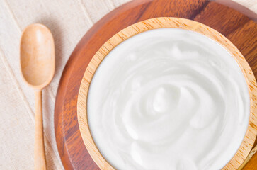 Fototapeta na wymiar The Greek yogurt in a wooden bowl and dry barley on table.