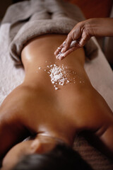 Salt sprinkle, back scrub and spa specialist hands with woman customer at a hotel with massage. Exfoliate therapy, luxury and relax treatment of a female person rest for skincare and wellness