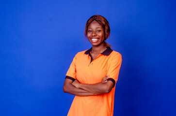 Confident young woman keeping a smiling while standing isolated on blue background