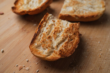Freshly toasted bread slices for breakfast at home. They are on a wooden table.