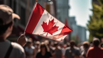 Fotobehang hand waving a Canadian flag during a Canada Day parade © 22Imagesstudio