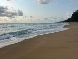 Sandy sand on the seashore with a wave