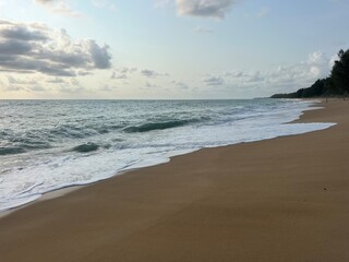 Sandy sand on the seashore with a wave