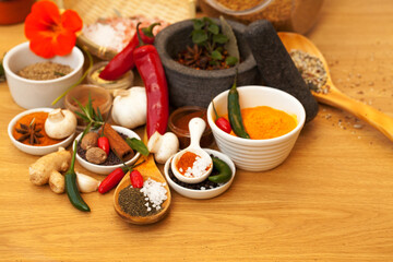 Mortar, food and spices on table for cooking gourmet meal, chili seasoning or flavor pestle. Pepper vegetables, kitchen condiments and variety of plant herbs for brunch, healthy diet or vitamins.