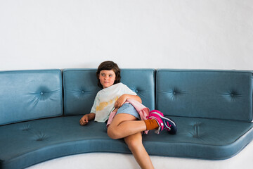 Obraz premium Happy smiling handsome girl resting on a sofa