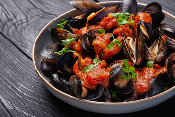 Mussel and tomato salad on a plate on the kitchen table