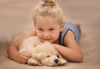 Girl kid hug her puppy, relax at home and happy with sleeping golden retriever dog and child with smile. Happiness, pet care and love with young female and her domestic animal lying on wood floor