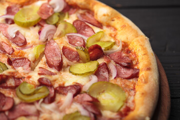 Italian or French pizza with different ingredients. Sausage, meat, cheese, tomatoes.