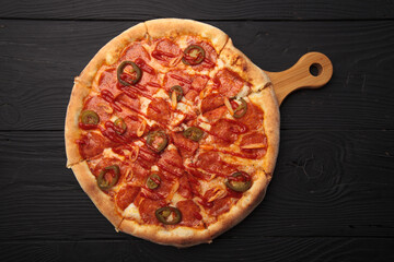 Italian or French pizza with different ingredients. Sausage, meat, cheese, tomatoes.